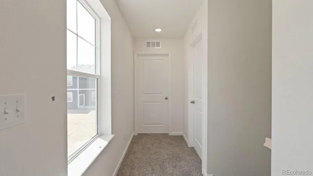 a view of a hallway with wooden floor and windows