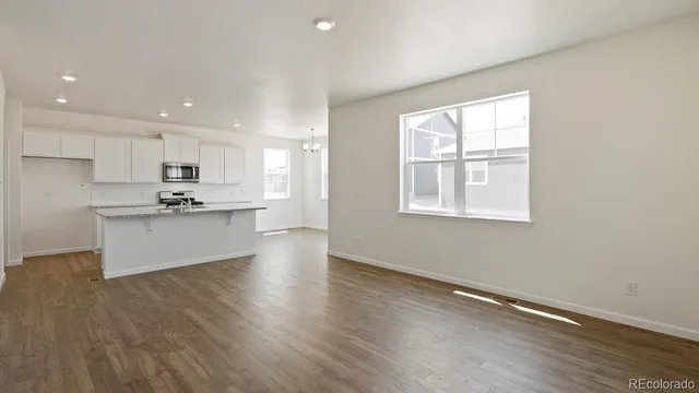 a view of kitchen with granite countertop cabinets and refrigerator