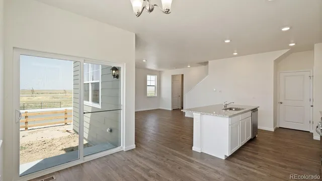 a open kitchen with white cabinets and wooden floor