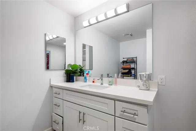 a bathroom with a sink vanity and a mirror