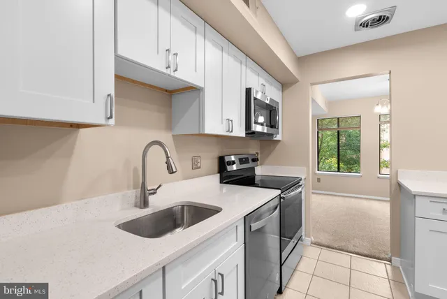 a kitchen with stainless steel appliances granite countertop a sink stove and a refrigerator