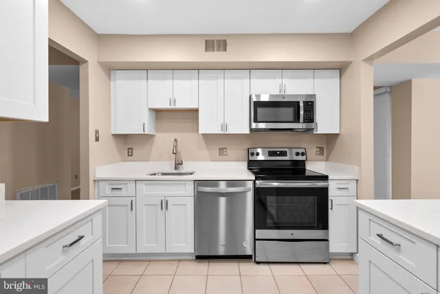 a kitchen with white cabinets and stainless steel appliances