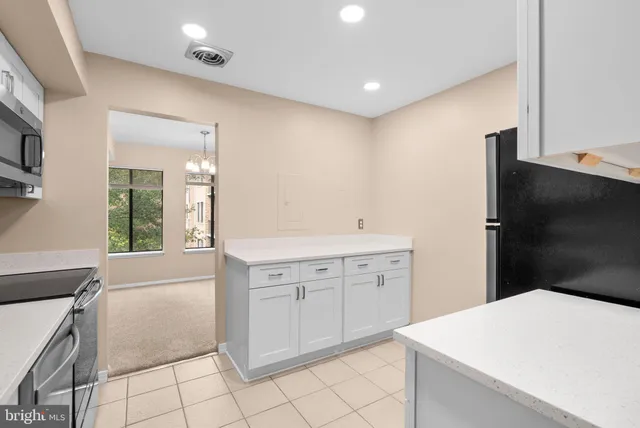 a kitchen with white cabinets a sink and white appliances