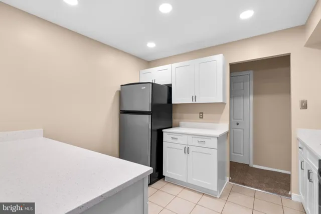 a kitchen with a refrigerator sink and cabinets