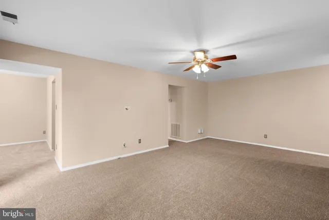 an empty room with closet and a ceiling fan