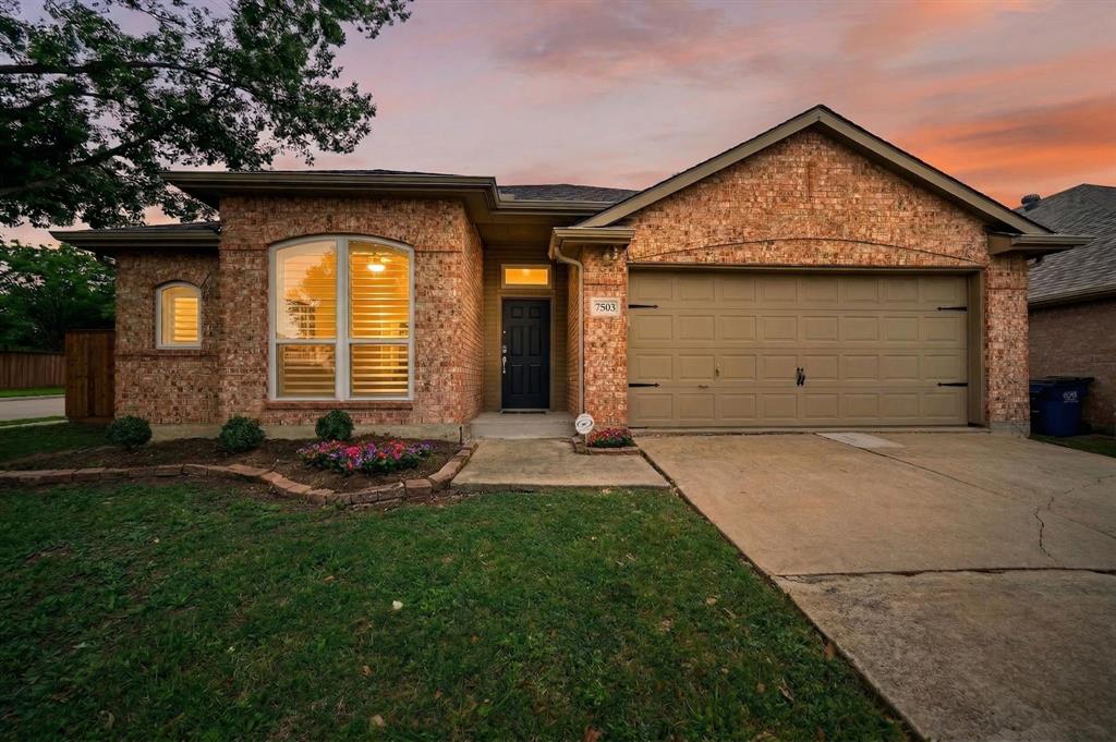 The property features a brick exterior, an attached two-car garage, and a concrete driveway