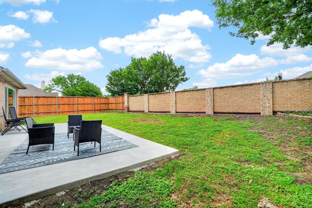 7503 Vista Ridge Lane Sachse, TX 75048 - Photo 29 of 33 The property features a concrete patio area, a lawn, and a brick privacy wall