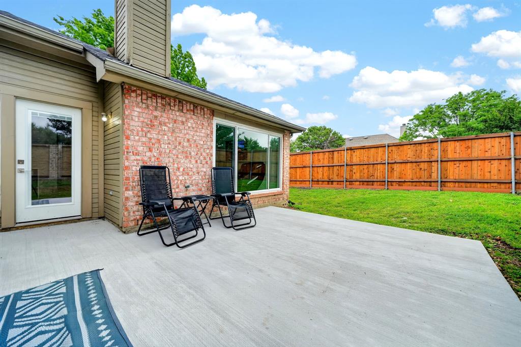 7503 Vista Ridge Lane Sachse, TX 75048 - Photo 30 of 33 The property features a concrete patio area, a brick exterior, and a well-maintained lawn