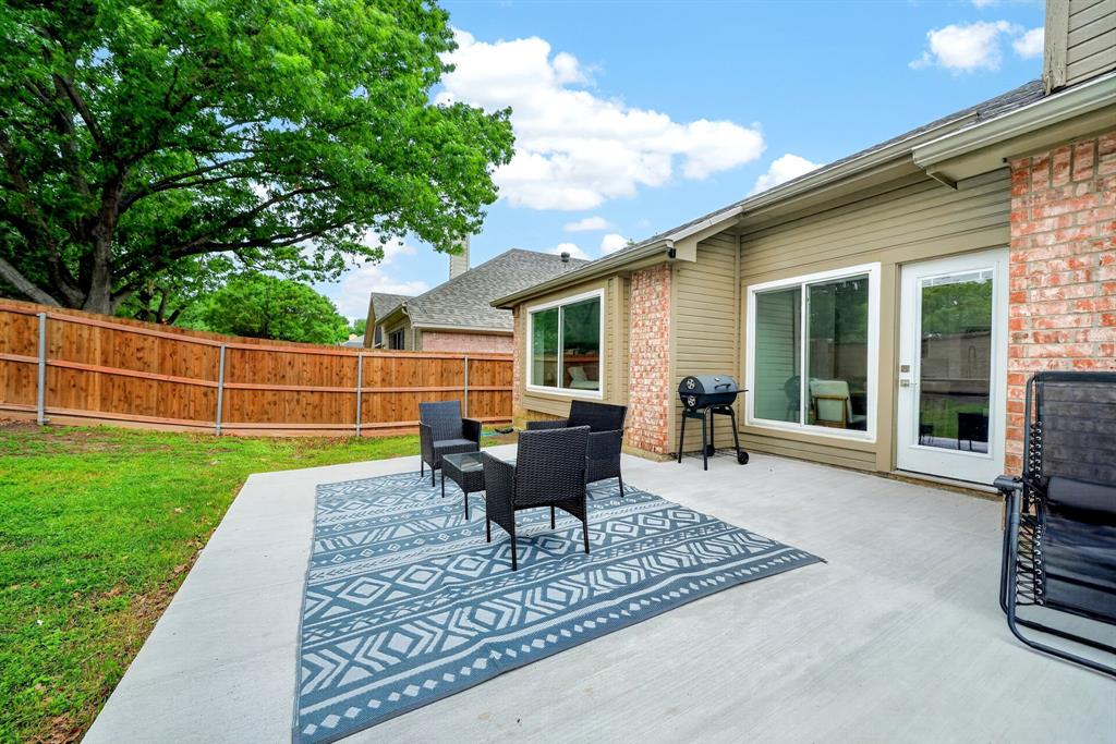 7503 Vista Ridge Lane Sachse, TX 75048 - Photo 31 of 33 The property features a concrete patio area with direct access to the interior through a glass-paneled door and large windows