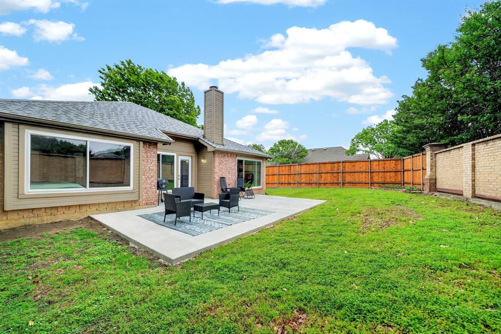 7503 Vista Ridge Lane Sachse, TX 75048 - Photo 32 of 33 The property features a spacious backyard with a well-maintained lawn and a patio, perfect for outdoor enjoyment
