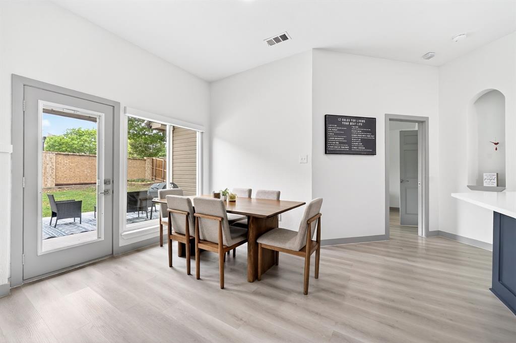 7503 Vista Ridge Lane Sachse, TX 75048 - Photo 5 of 33 This dining area features light-colored flooring, white walls, and a large window and glass-paned door providing views of the backyard