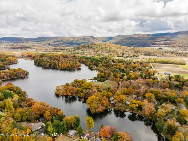 an aerial view of ocean and residential houses with outdoor space