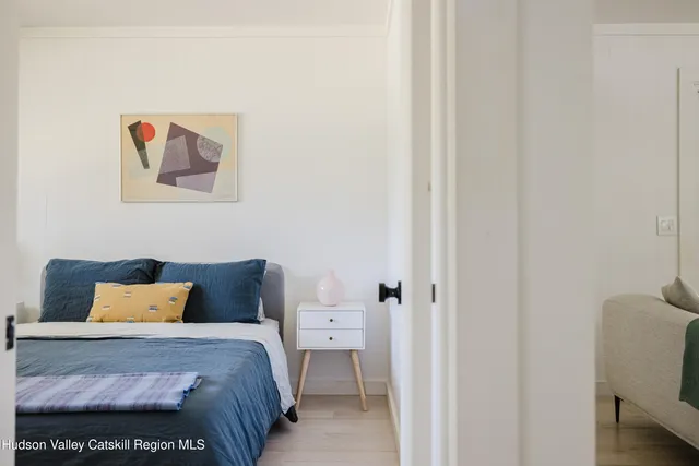 a bedroom with a bed and a painting on the wall