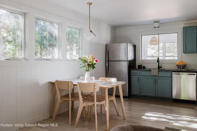 a kitchen with a table chairs refrigerator and microwave