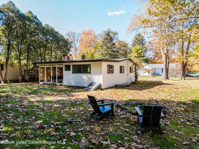 a view of a house with backyard and sitting area