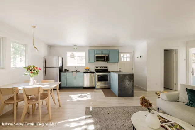a living room with furniture a refrigerator and kitchen view