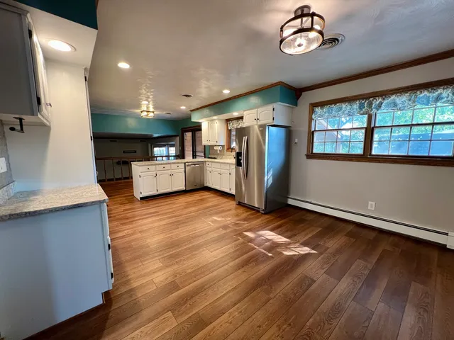 a kitchen with cabinets and wooden floor