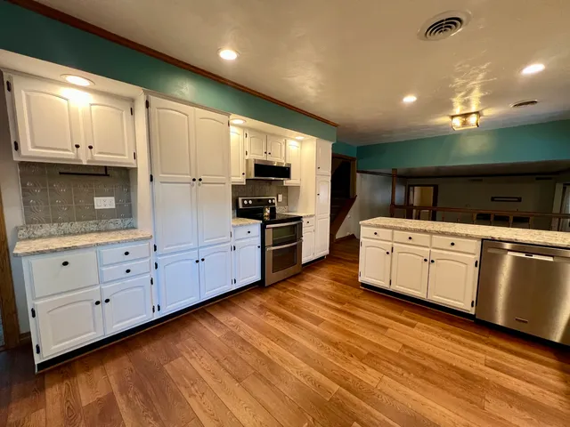 a view of kitchen with stainless steel appliances granite countertop sink refrigerator and stove