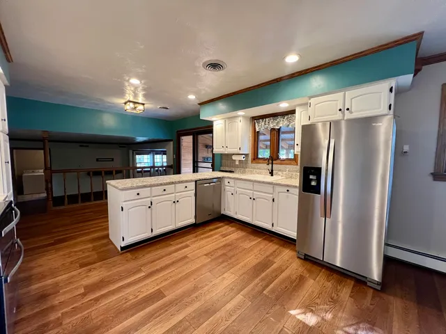 a view of kitchen with refrigerator stove microwave and cabinets