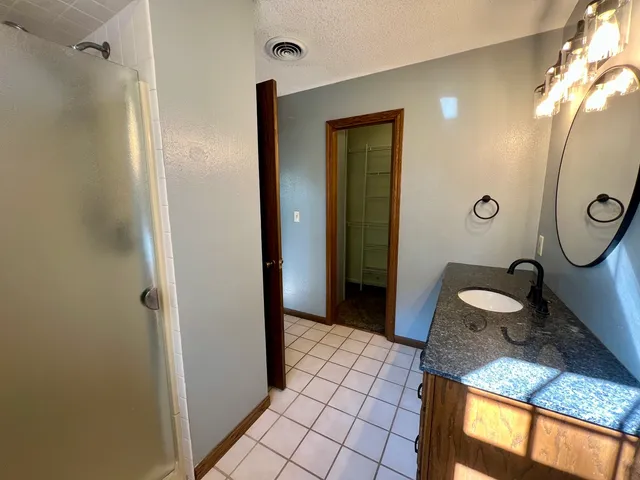 a bathroom with a granite countertop sink a toilet and mirror