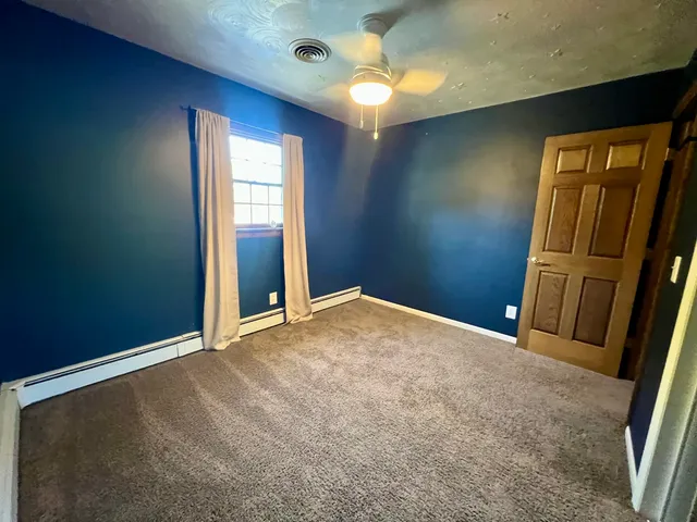 a backyard of a house with table and chairs plants and large tree