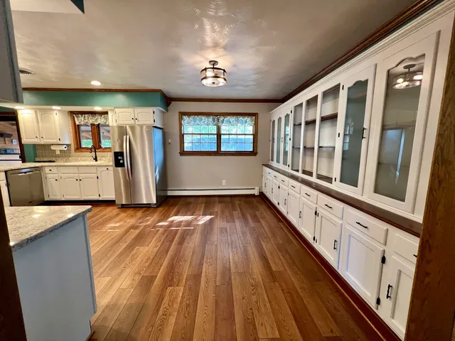 a kitchen with stainless steel appliances wooden floors and refrigerator