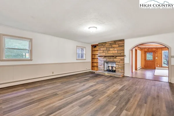a living room with furniture a fireplace a flat screen tv and wooden floor