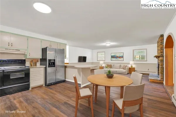 a large kitchen with cabinets wooden floor and stainless steel appliances