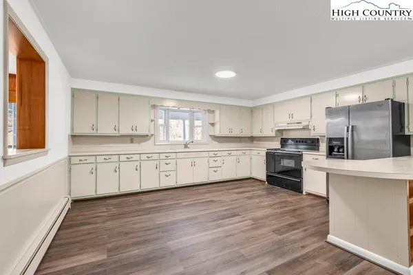 a kitchen with granite countertop a refrigerator stove top oven and sink