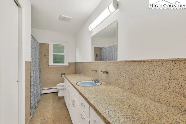 a bathroom with a granite countertop sink and a mirror