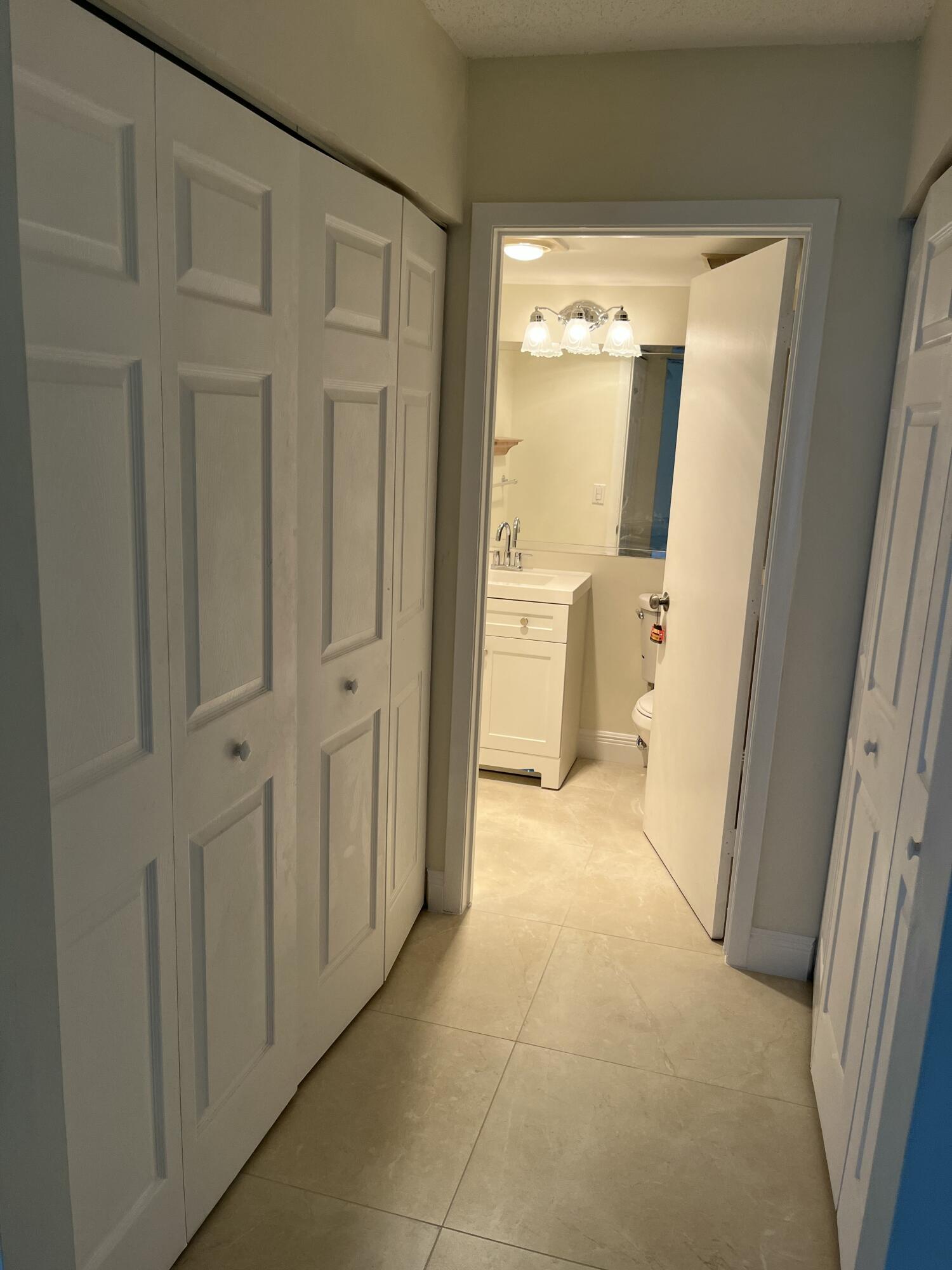 1012 Green Pine Boulevard, Unit B1 West Palm Beach, FL 33409 - Photo 11 of 13 a view of a hallway with wooden shelves