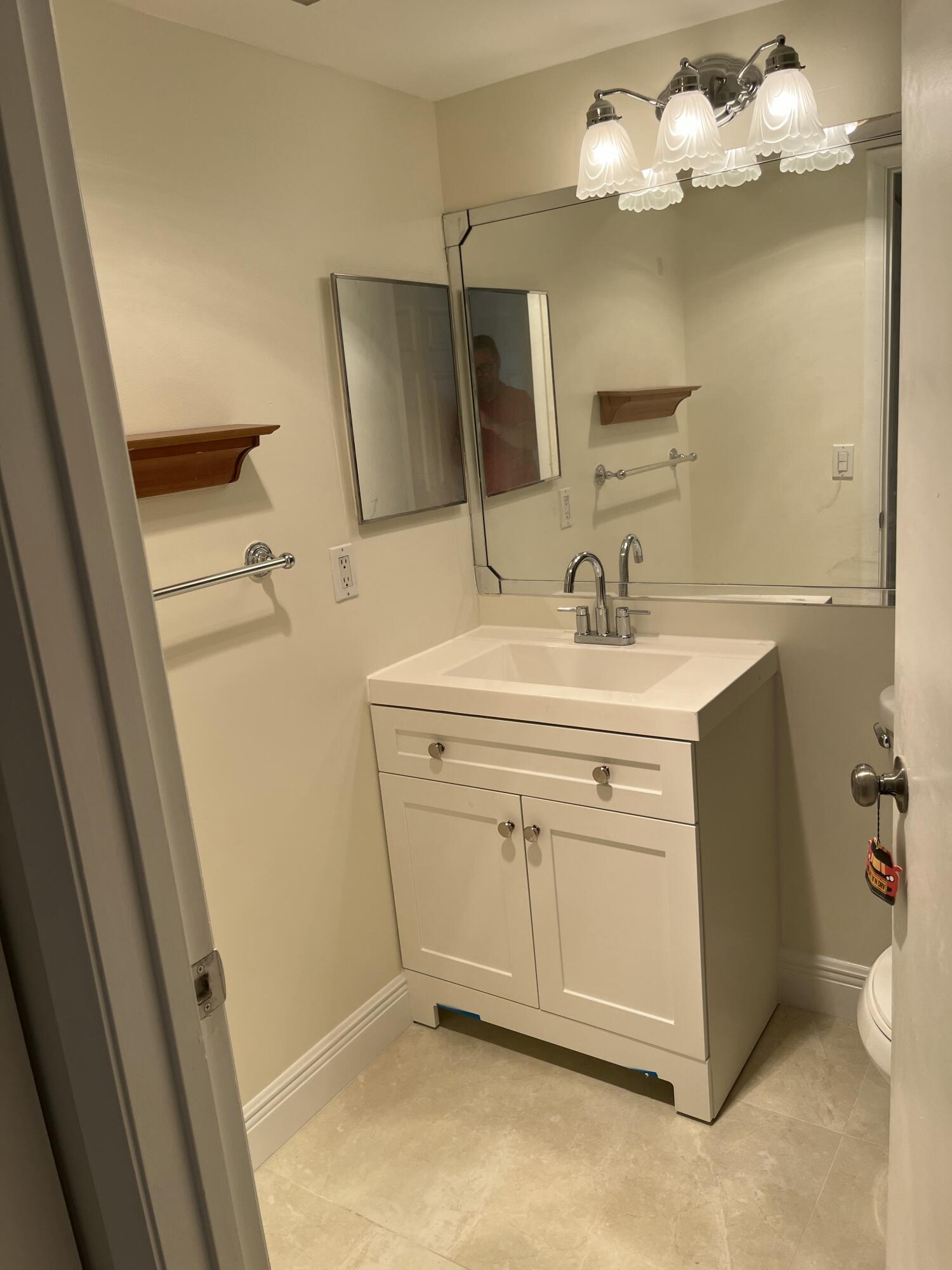 1012 Green Pine Boulevard, Unit B1 West Palm Beach, FL 33409 - Photo 12 of 13 a bathroom with a sink vanity and mirror