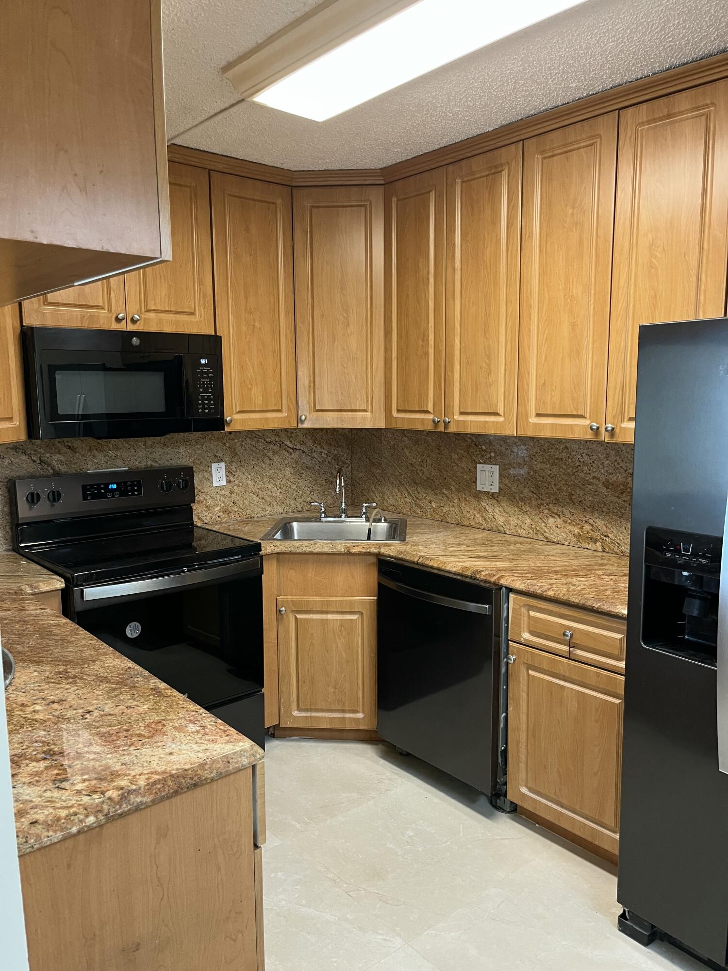 1012 Green Pine Boulevard, Unit B1 West Palm Beach, FL 33409 - Photo 3 of 13 a kitchen with stainless steel appliances granite countertop a stove a sink and a microwave