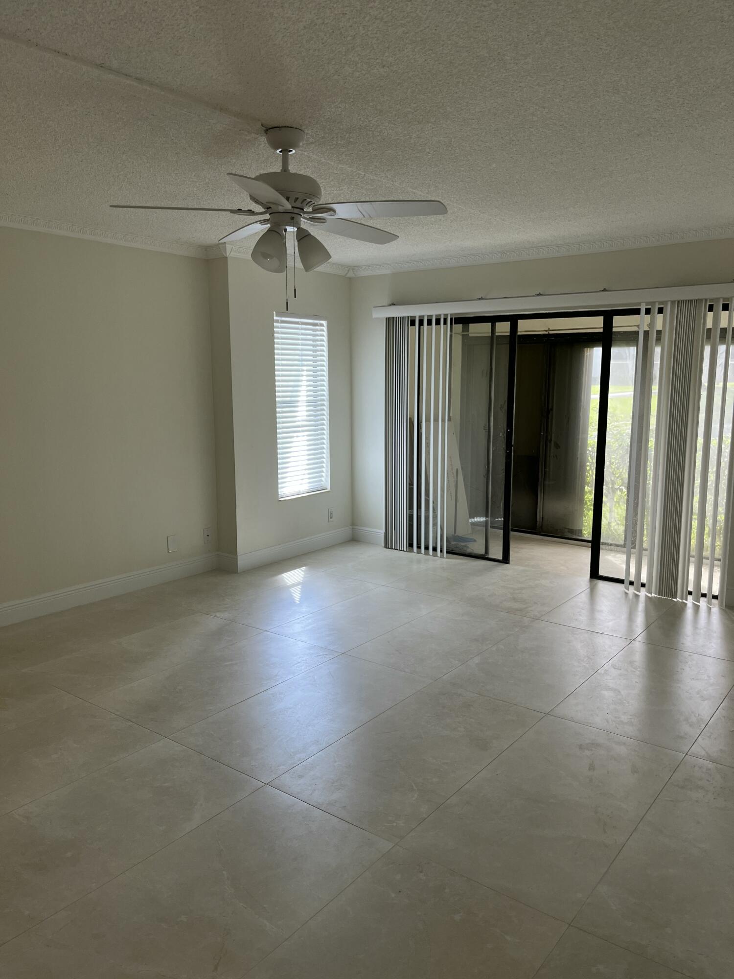 1012 Green Pine Boulevard, Unit B1 West Palm Beach, FL 33409 - Photo 5 of 13 an empty room with windows and fan
