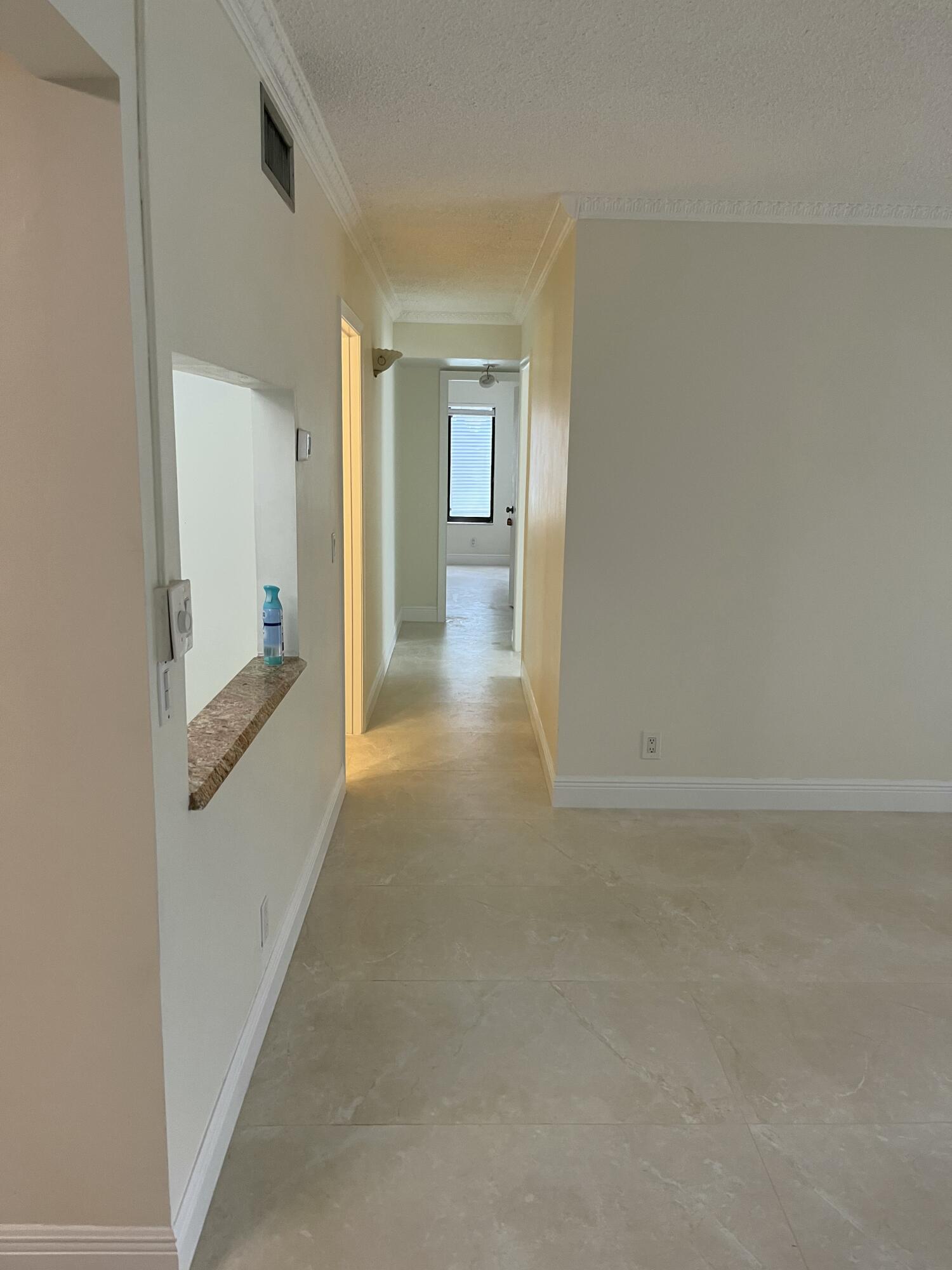 1012 Green Pine Boulevard, Unit B1 West Palm Beach, FL 33409 - Photo 6 of 13 a view of a hallway with wooden floor and a bathroom