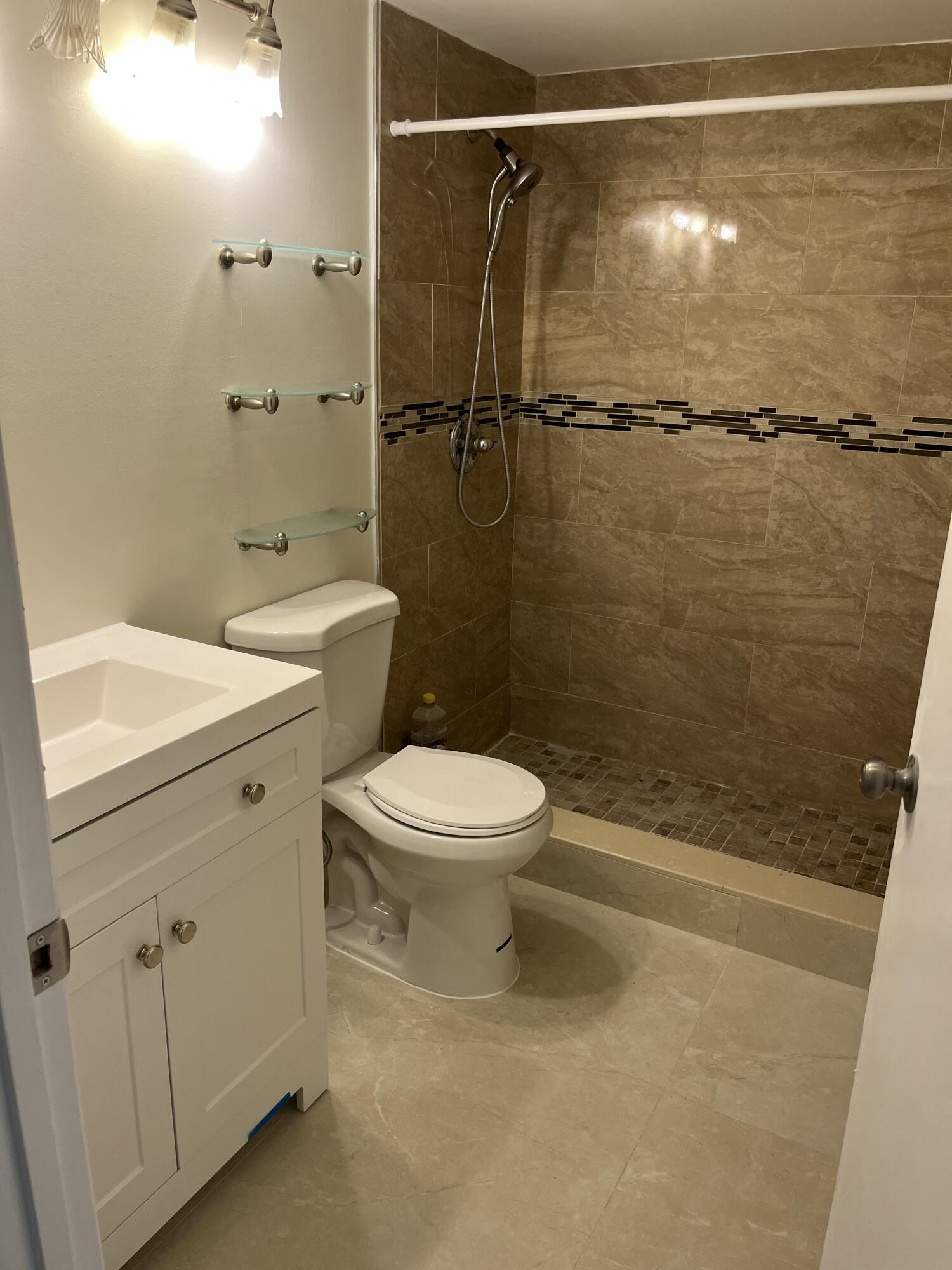 1012 Green Pine Boulevard, Unit B1 West Palm Beach, FL 33409 - Photo 7 of 13 a bathroom with a toilet sink and shower
