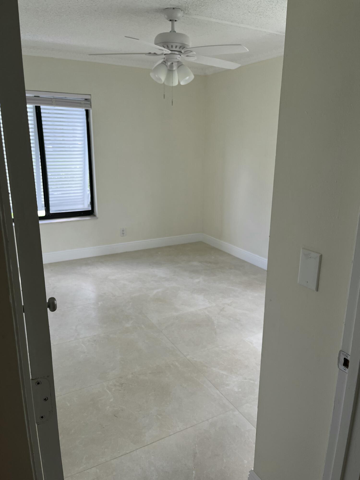 1012 Green Pine Boulevard, Unit B1 West Palm Beach, FL 33409 - Photo 9 of 13 an empty room with a window and a fan