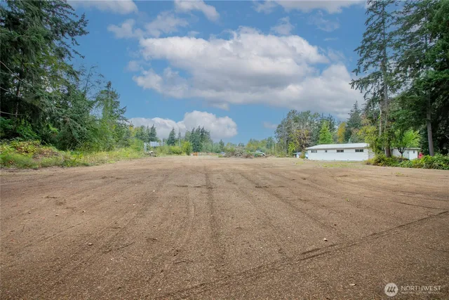 a view of dirt road with a building in background