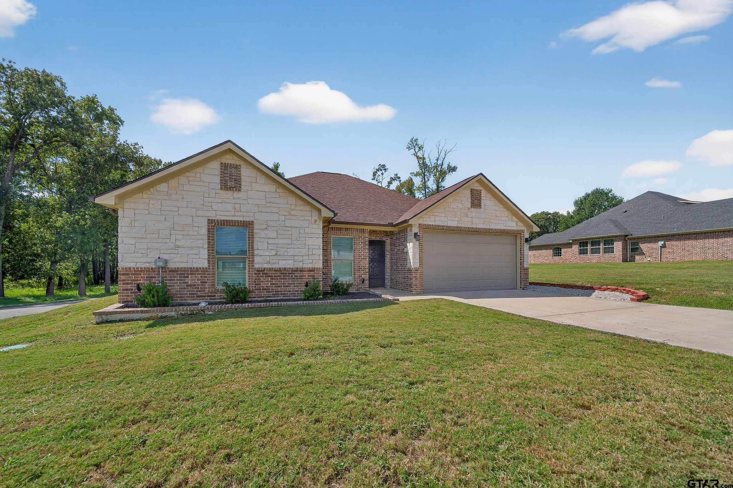 23001 Red Azalea Lane Lindale, TX 75771 - Photo 2 of 35 a front view of a house with a yard and garage