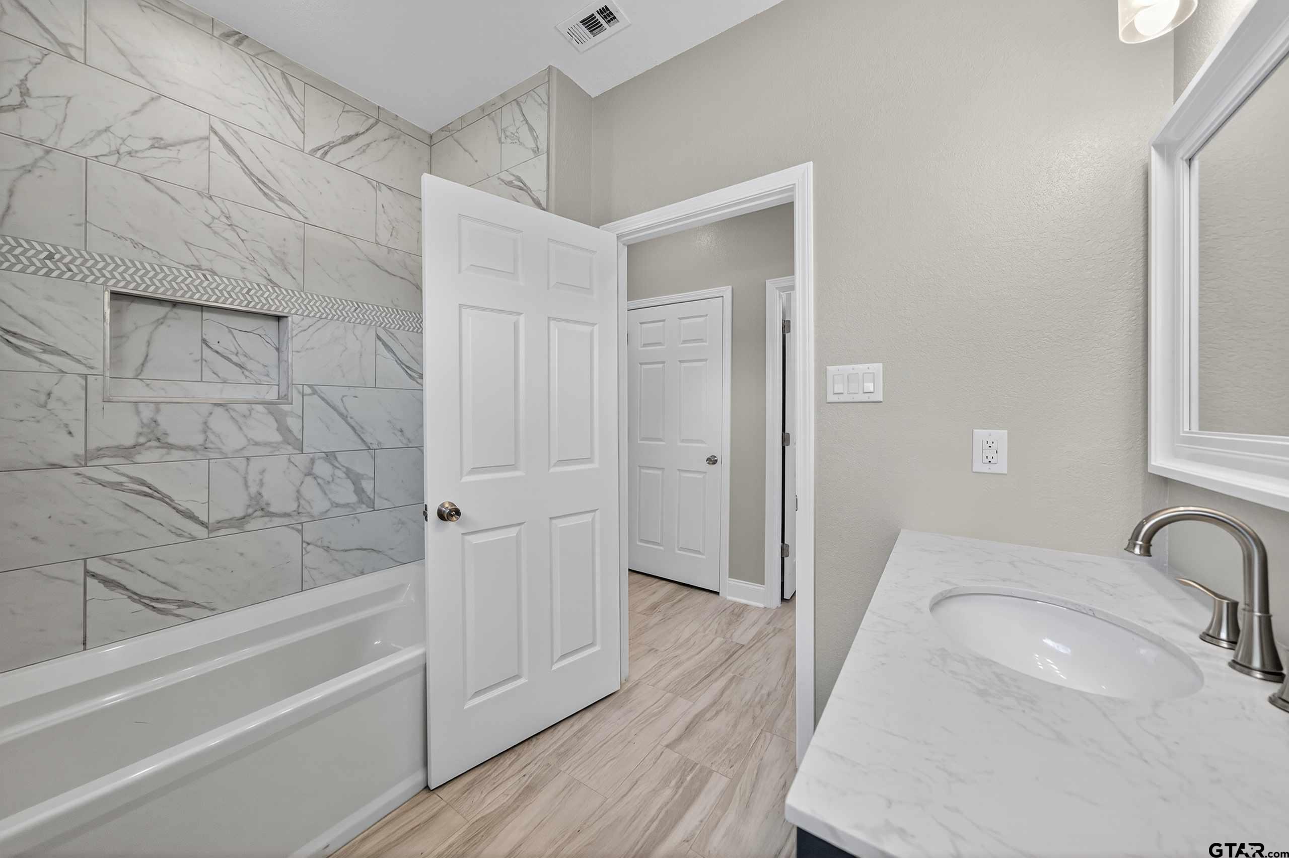 23001 Red Azalea Lane Lindale, TX 75771 - Photo 25 of 35 a bathroom with a tub shower vanity and a sink