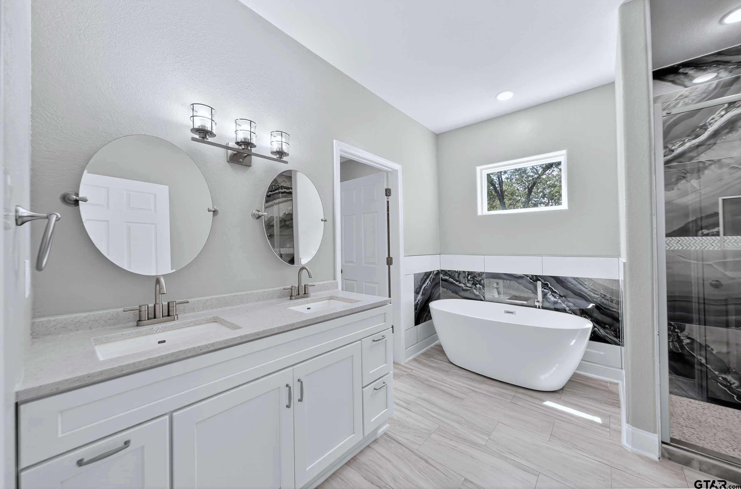 23001 Red Azalea Lane Lindale, TX 75771 - Photo 30 of 35 a en suite bathroom with a double vanity sink double mirror and bathtub