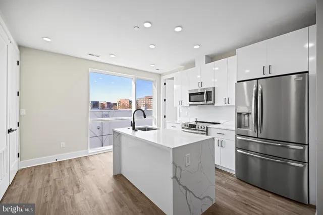 a kitchen with stainless steel appliances a refrigerator stove microwave and sink