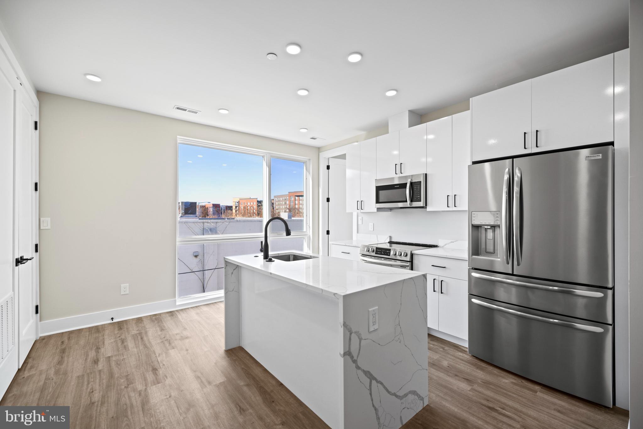 a kitchen with stainless steel appliances a refrigerator stove microwave and sink