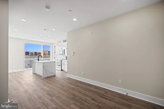 a view of a kitchen with wooden floor and a sink