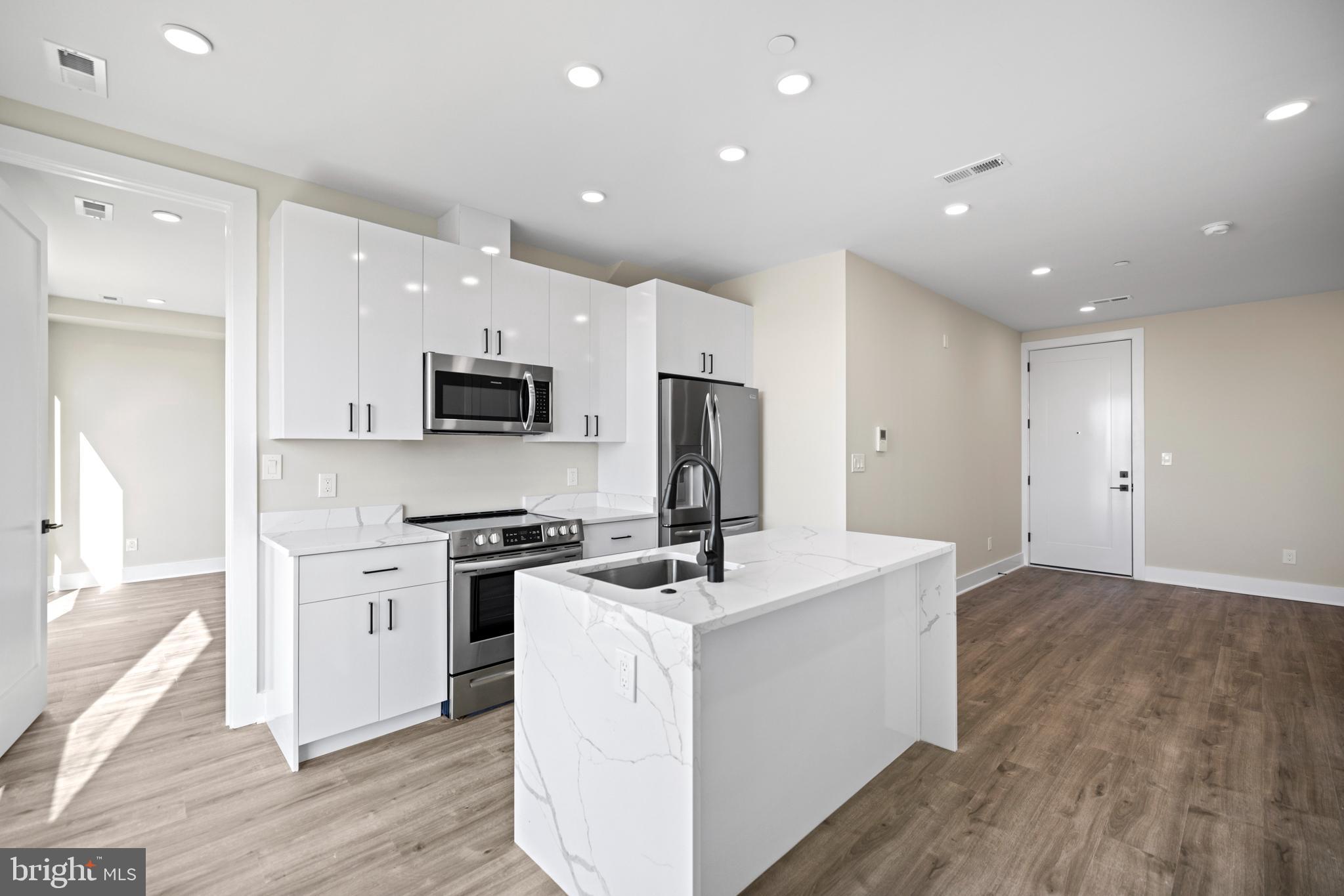 824 18th Street Northeast, Unit 11 Washington, DC 20002 - Photo 8 of 17 a kitchen with a sink stainless steel appliances and white cabinets