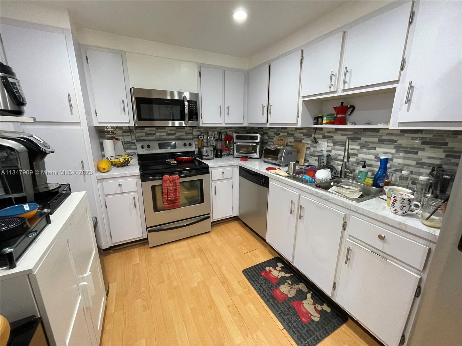 Ives Estates Miami, FL 33179 - Photo 7 of 34 a kitchen with stainless steel appliances a stove microwave and sink