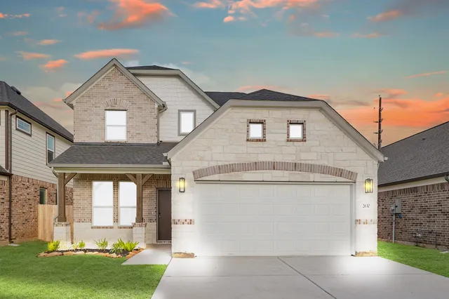 a front view of a house with a yard and garage