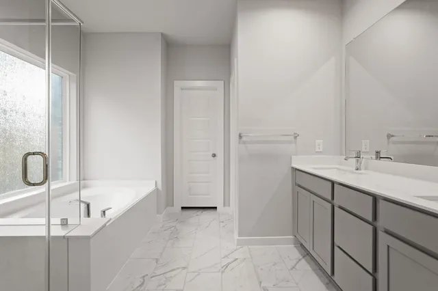 a bathroom with a tub sink and mirror