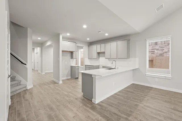 a large kitchen with stainless steel appliances kitchen island granite countertop a large counter top and a stove top oven