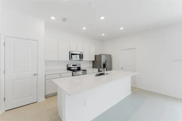 a kitchen with stainless steel appliances a refrigerator sink and stove